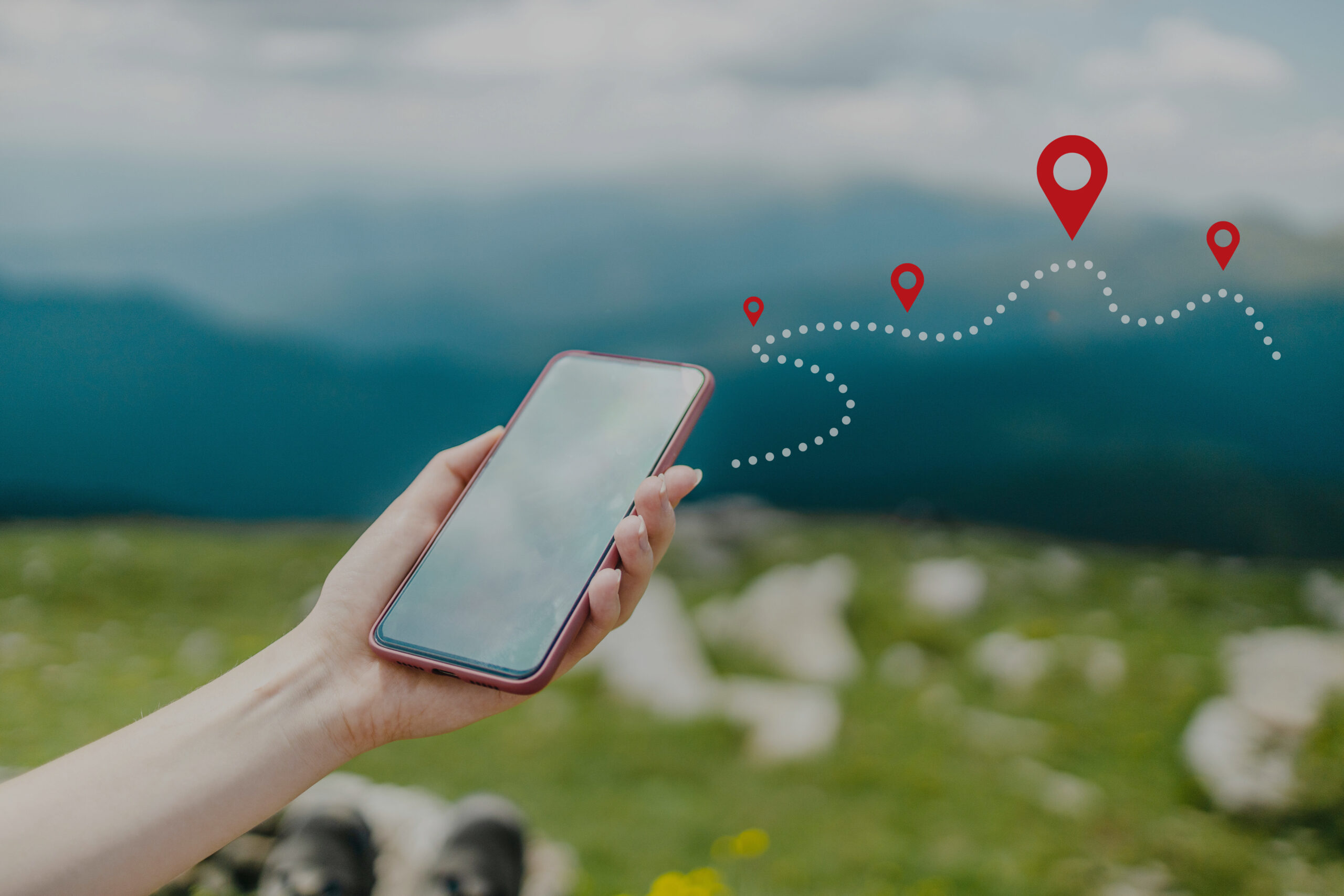 Woman hand using smart phone on top of mountain with navigator location point. Amazing Carpathians landscape background banner panorama with hills, clouds and forest at dawn